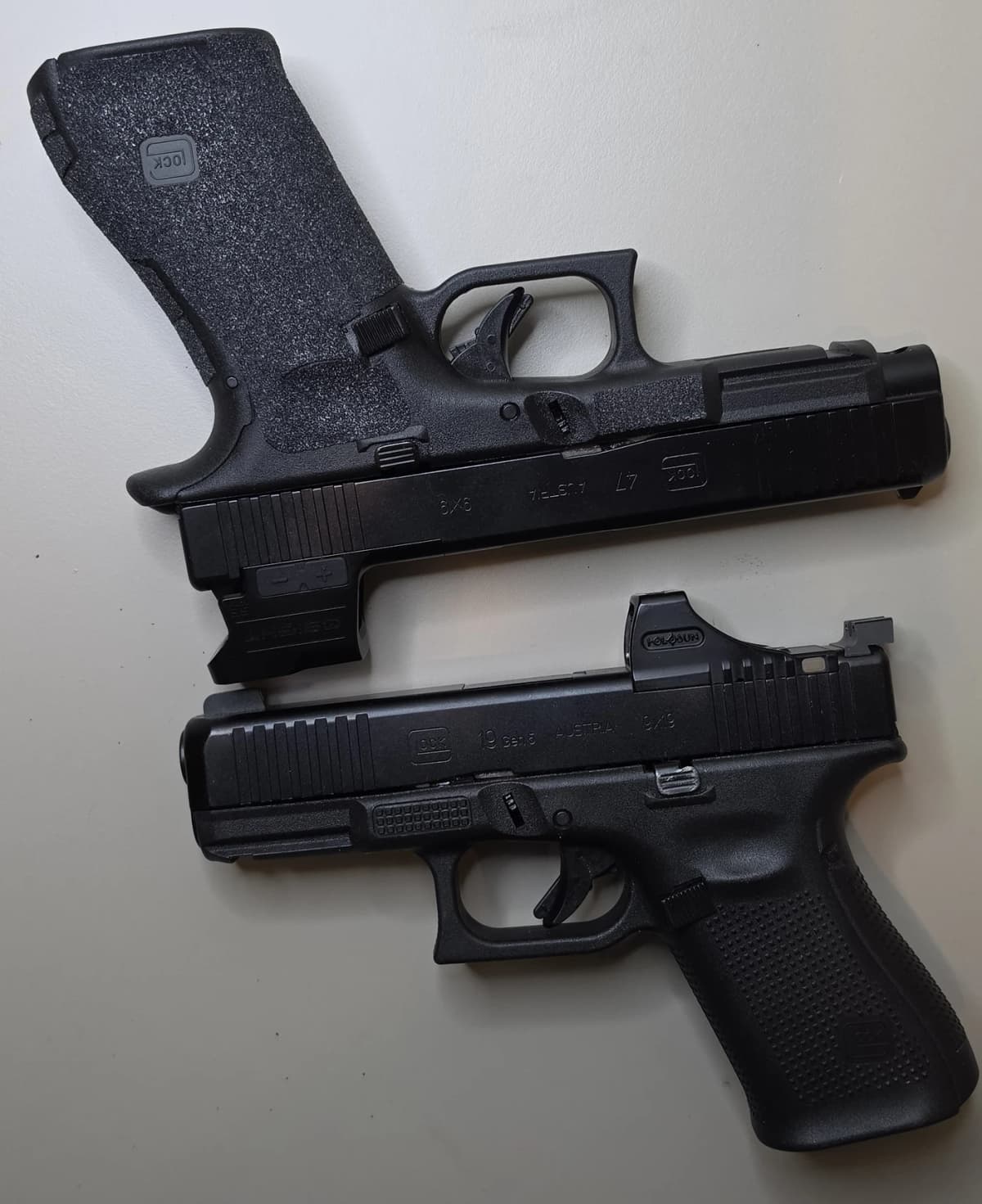 Glock 47 wearing the Osight SE MOS above a Glock 19 Gen5 wearing the Holosun SCS-MOS, showing both host slides
