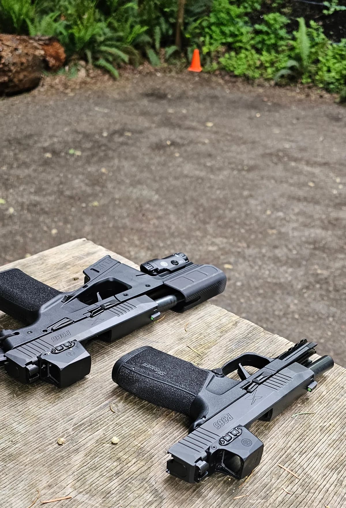 SIG P365-FLUX TACKIT and SIG P365 X-Macro staged on a shooting bench at an outdoor range, range cone in the background