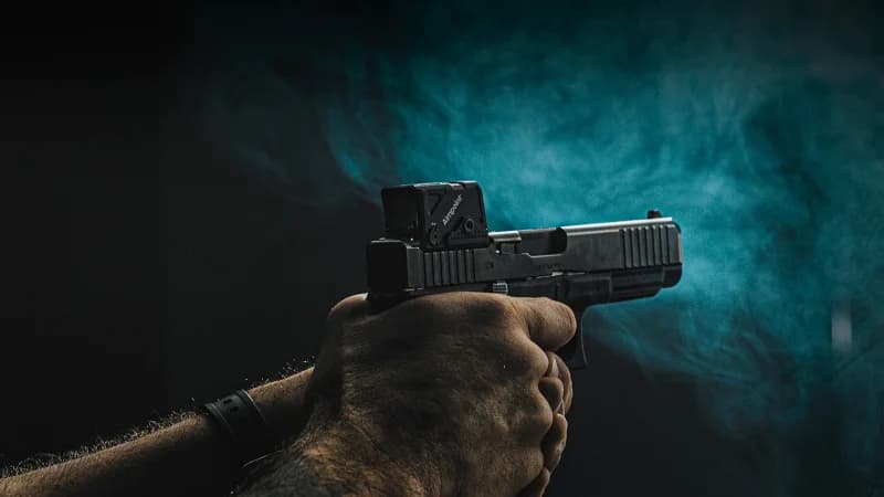 Aimpoint COA red dot sight mounted on a pistol, showing the enclosed emitter design and compact profile