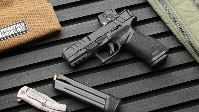 Springfield Armory Echelon pistol with Aimpoint COA red dot sight on black textured surface with magazine and EDC accessories