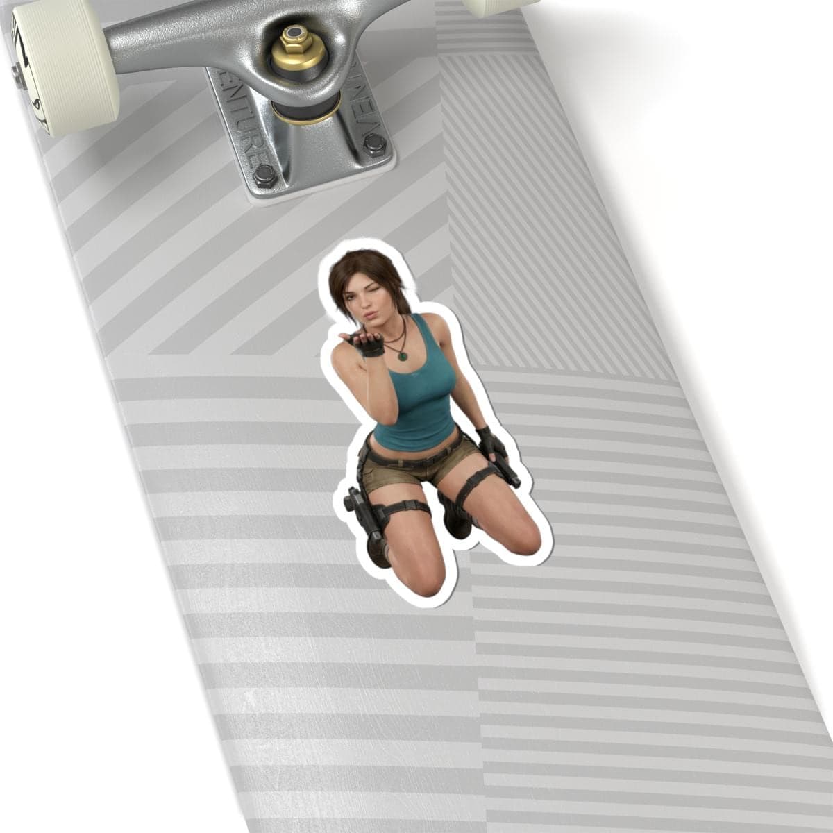 May include: A die-cut sticker featuring a woman in a teal tank top and khaki shorts, kneeling and blowing a kiss. The sticker has a white border and is placed on a skateboard.
