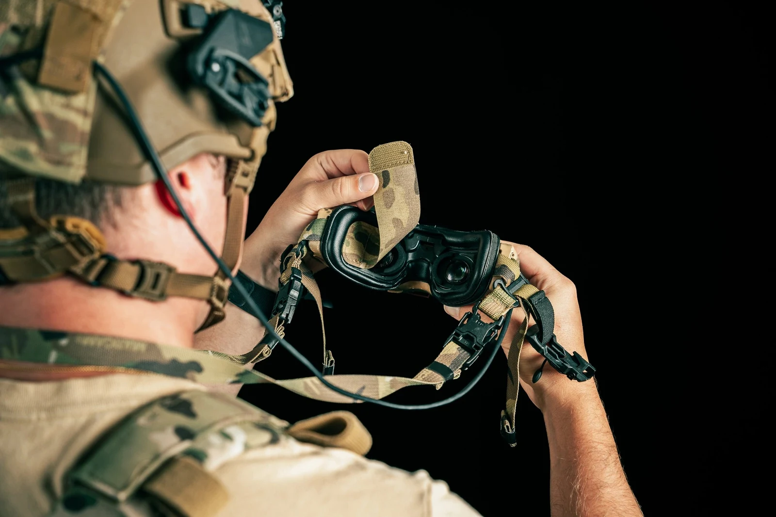 Close view of the included lens cover being lifted off the FPV goggle lenses by its adhesive hook and loop flap