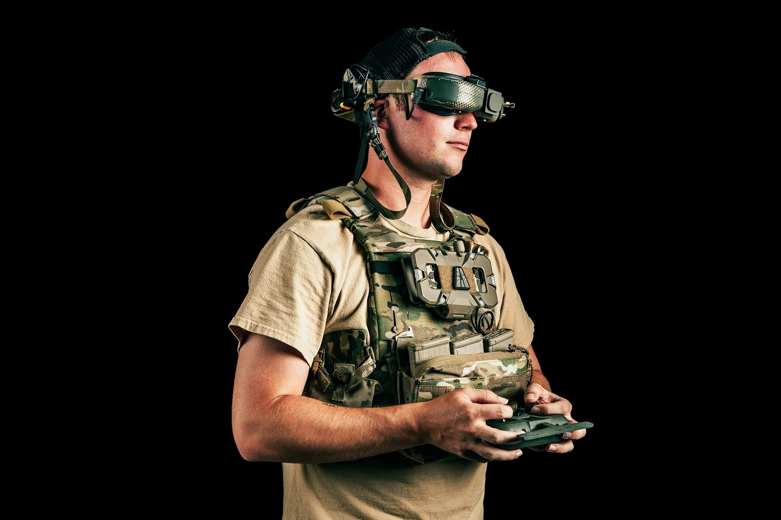 Operator wearing the FPV goggle on the standalone padded headband, flipped up on the forehead, while holding a drone controller