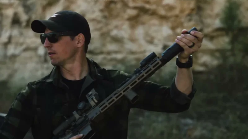 Shooter demonstrating the touch test by grabbing Ambient Arms EXO suppressor immediately after firing