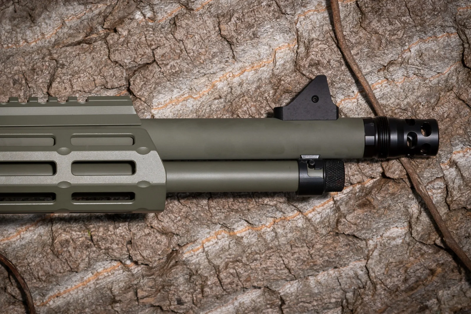 Angled Spade Technologies Scepter Plan B radial-ported muzzle brake installed on an OD green rifle barrel