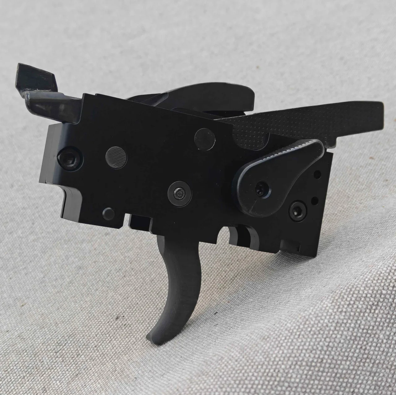 AS Designs ARHK drop-in forced reset trigger cassette, a black machined fire control unit with trigger, hammer, and selector