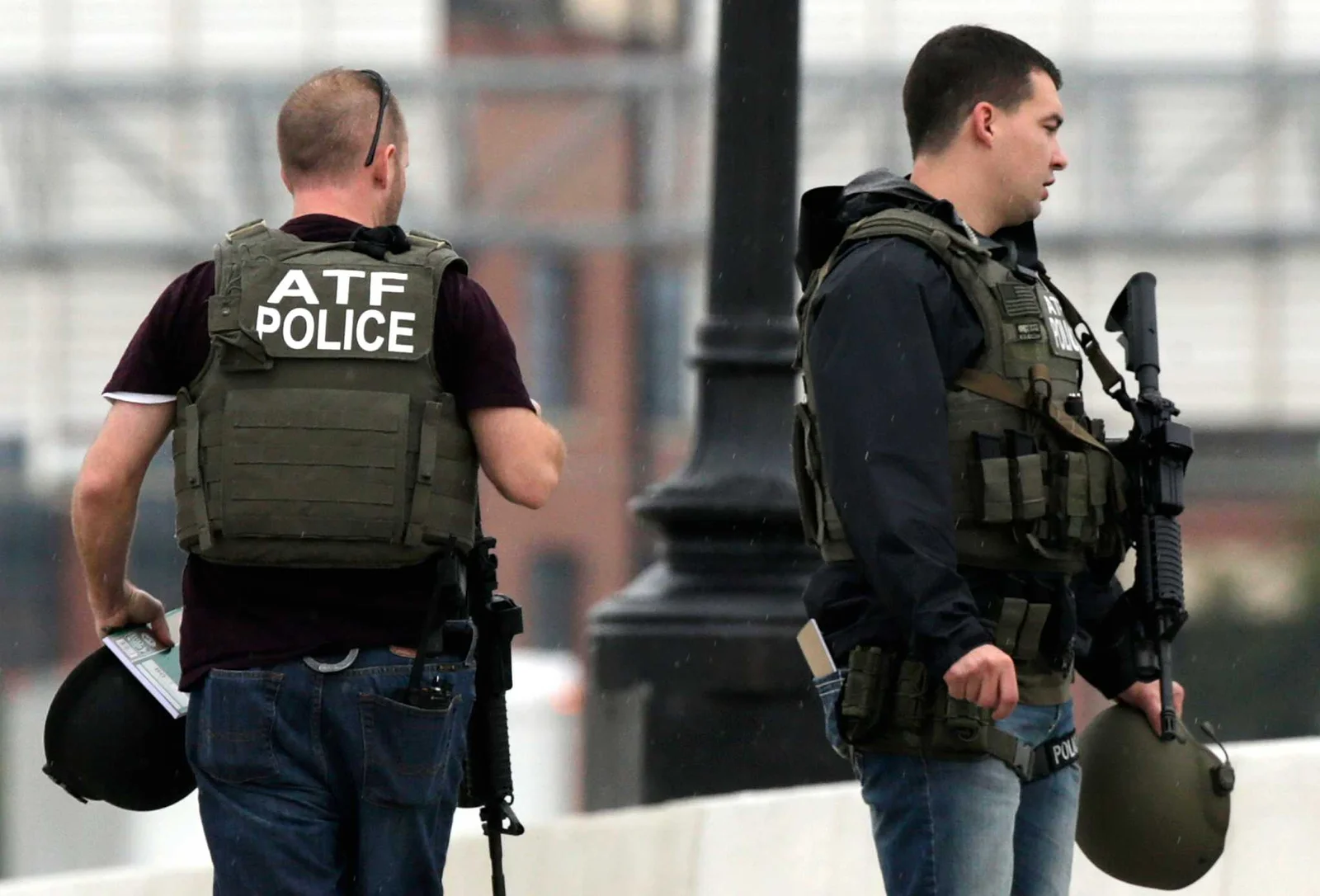 Two ATF agents in ATF Police plate carriers carrying carbines and helmets during a field operation