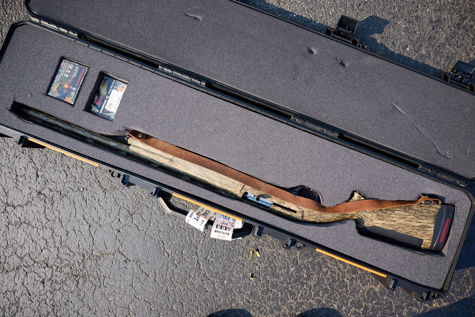 A traveler with a hard-sided rifle case at an airport check-in counter, the scenario the proposed 27 CFR 478.38 safe-transport rule is designed to cover