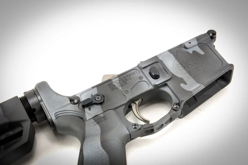 AR-15 lower receiver with safety selector, trigger, and magazine release visible, the install location for the Atrius G-Lever