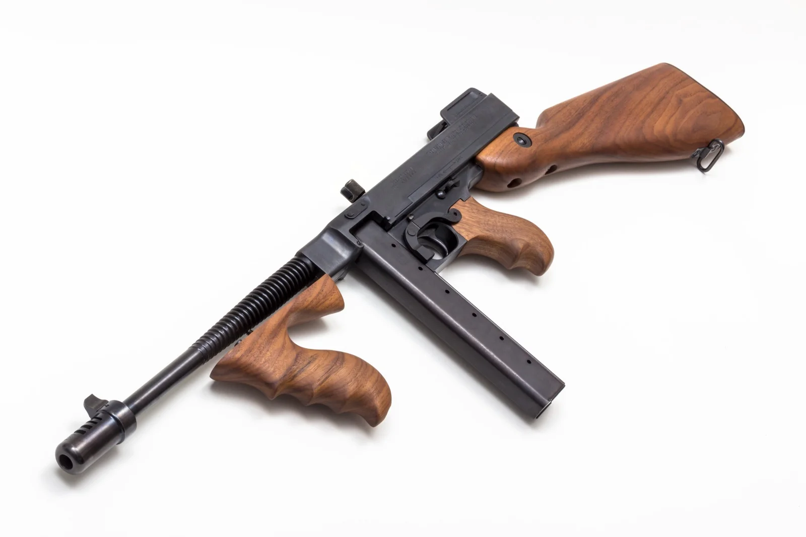 Auto-Ordnance Thompson 1927A-1 short-barreled rifle on a white background, showing the finned 10.5-inch barrel with Cutts compensator, vertical walnut foregrip, fixed walnut buttstock and 20-round stick magazine