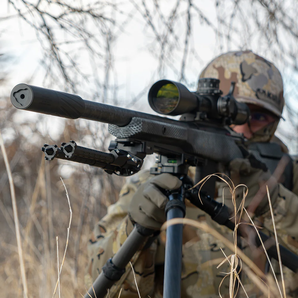 Hunter using a suppressed bolt-action rifle with BANISH suppressor in the field