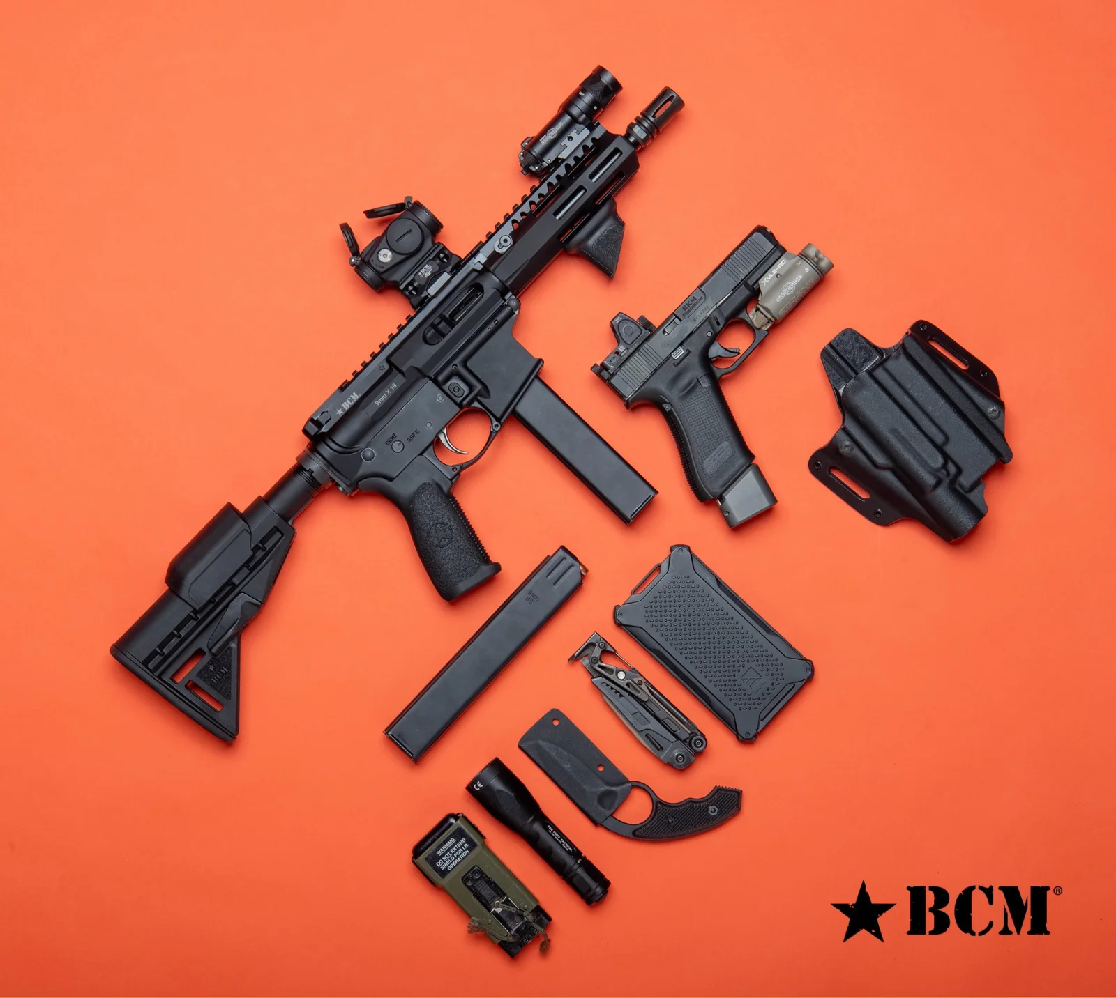 Bravo Company BCM9 arranged on an orange background beside a handgun, holster, magazines, flashlight, and other carry gear