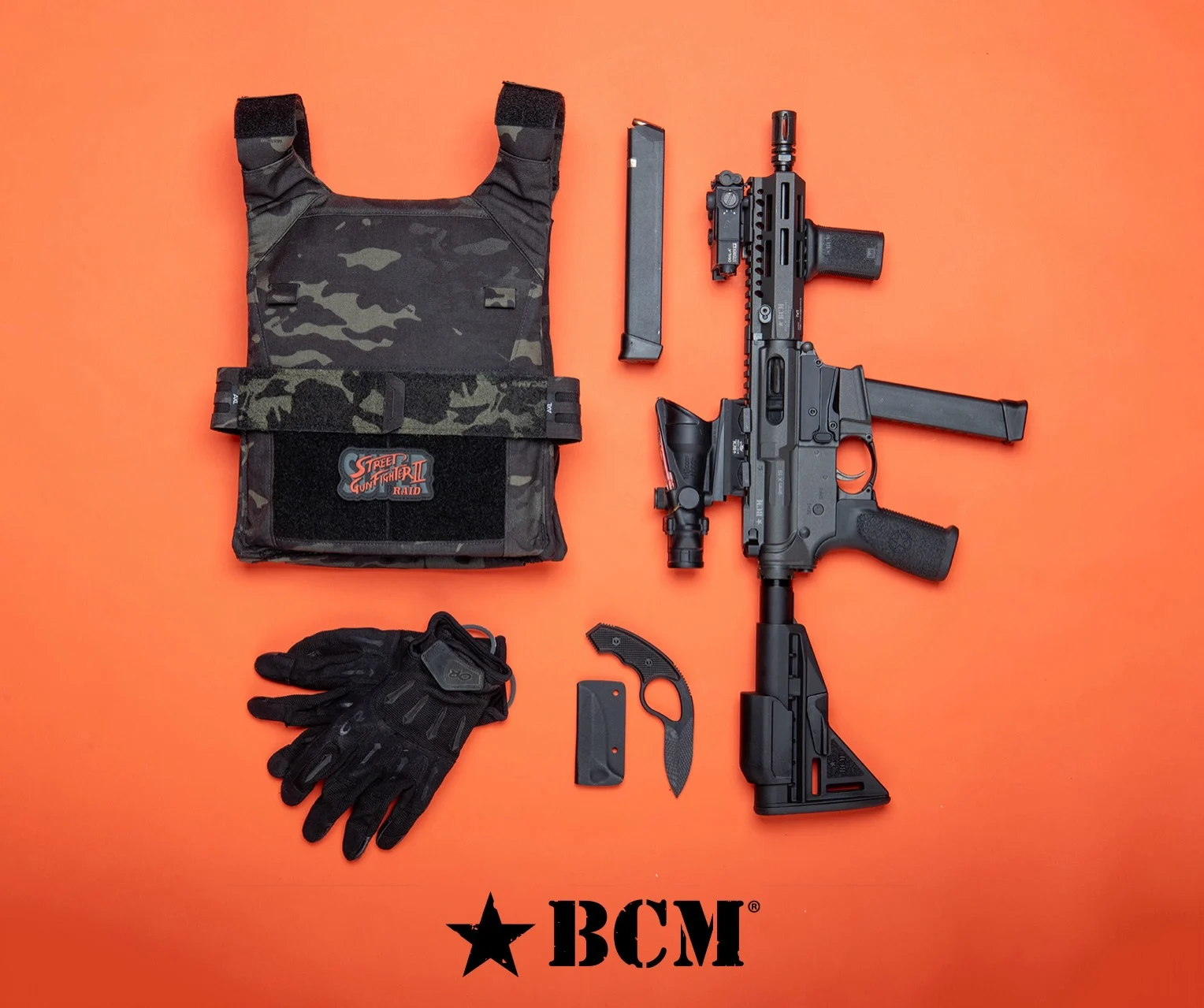 Bravo Company's BCM9 laid out on an orange backdrop with a plate carrier, gloves, and a knife, fed by a Glock 33-round magazine with a spare 33-rounder beside it
