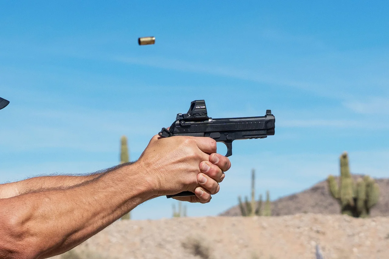 Ernest Langdon firing a Beretta 92 Elite LTT pistol, captured mid-recoil with brass ejecting