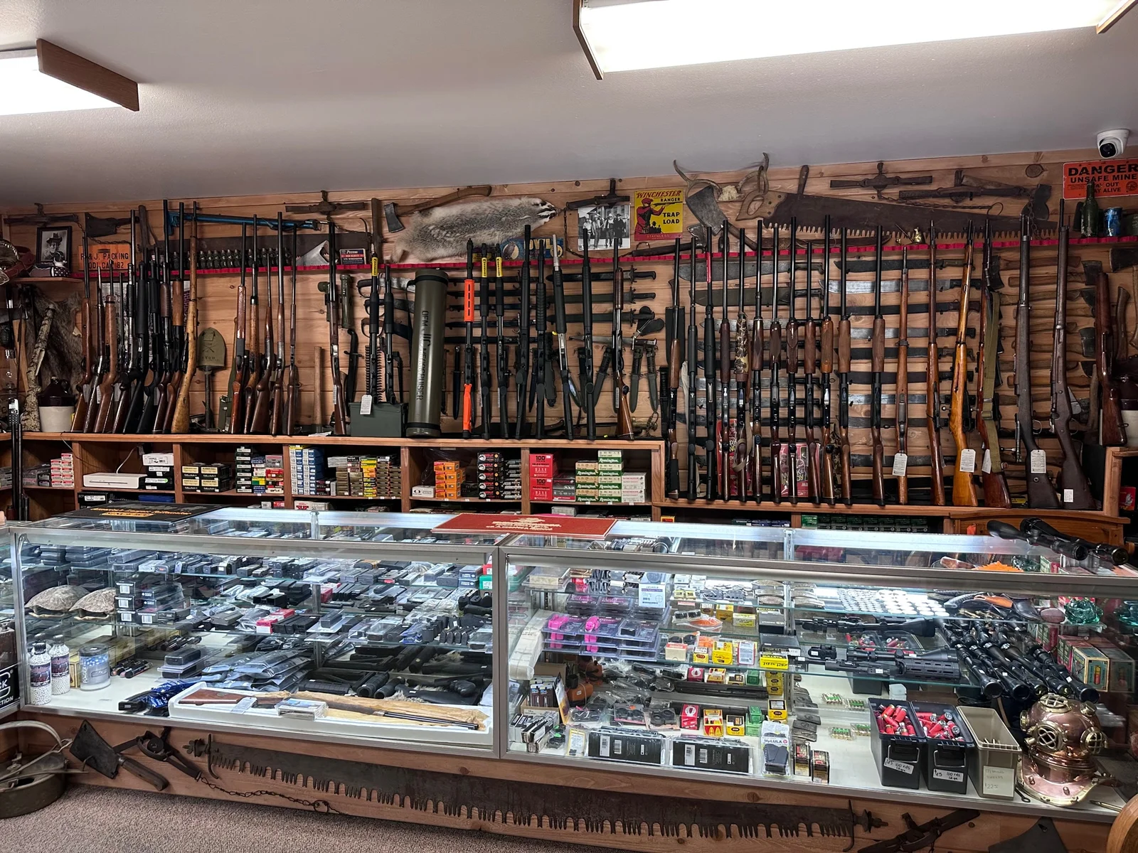 Display case and wall racks of rifles and shotguns inside Teresi Trading, a licensed firearms dealer in Lodi, California