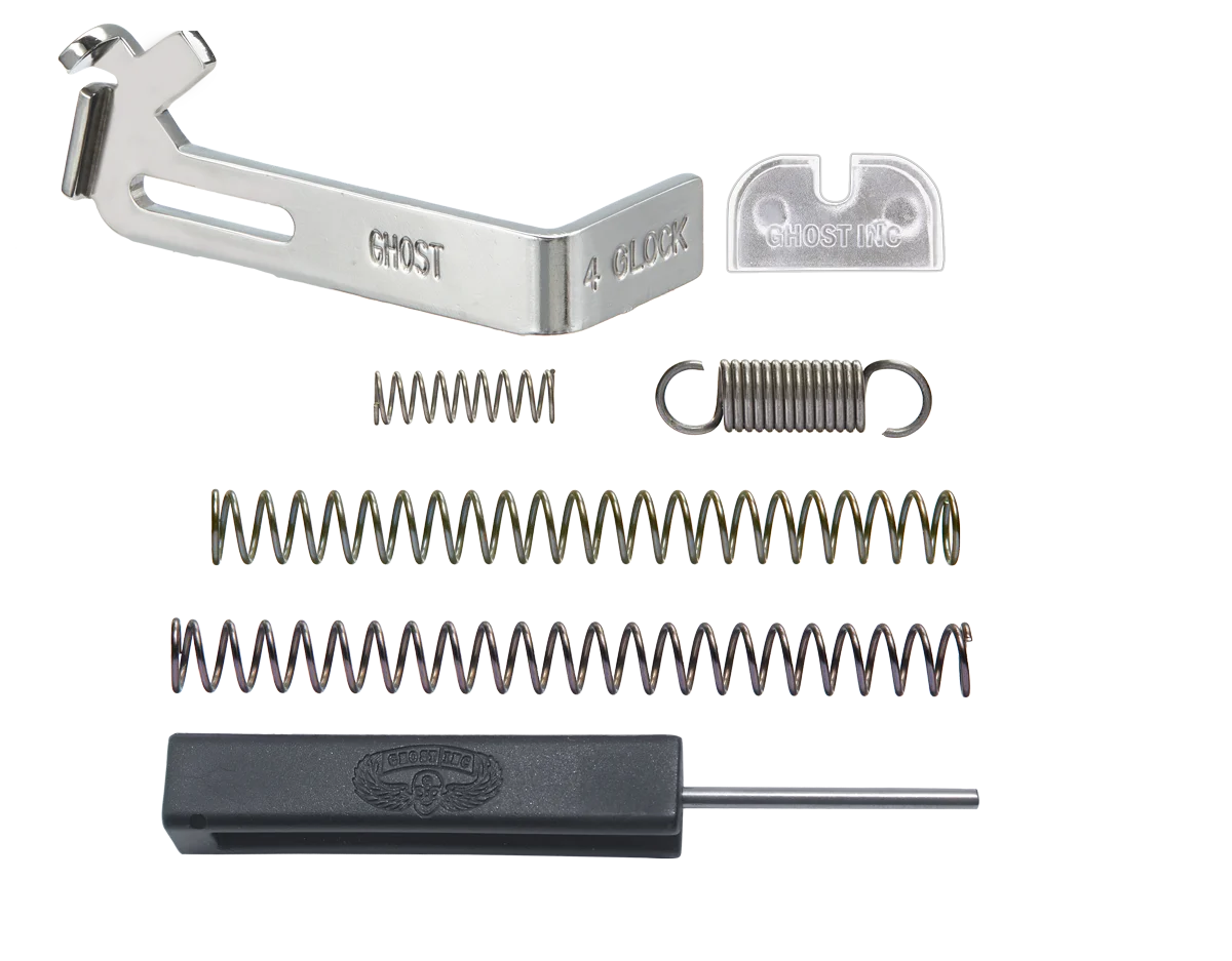 Glock trigger components and installation tools laid out on a black background
