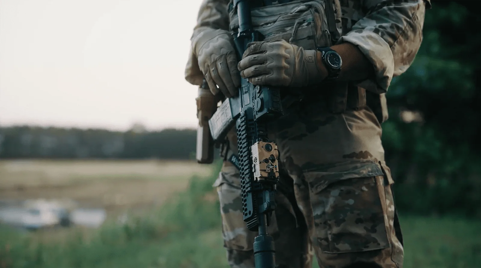 Colt Optics LP5X-P tactical aiming laser mounted on the handguard of a rifle held by a soldier in gear