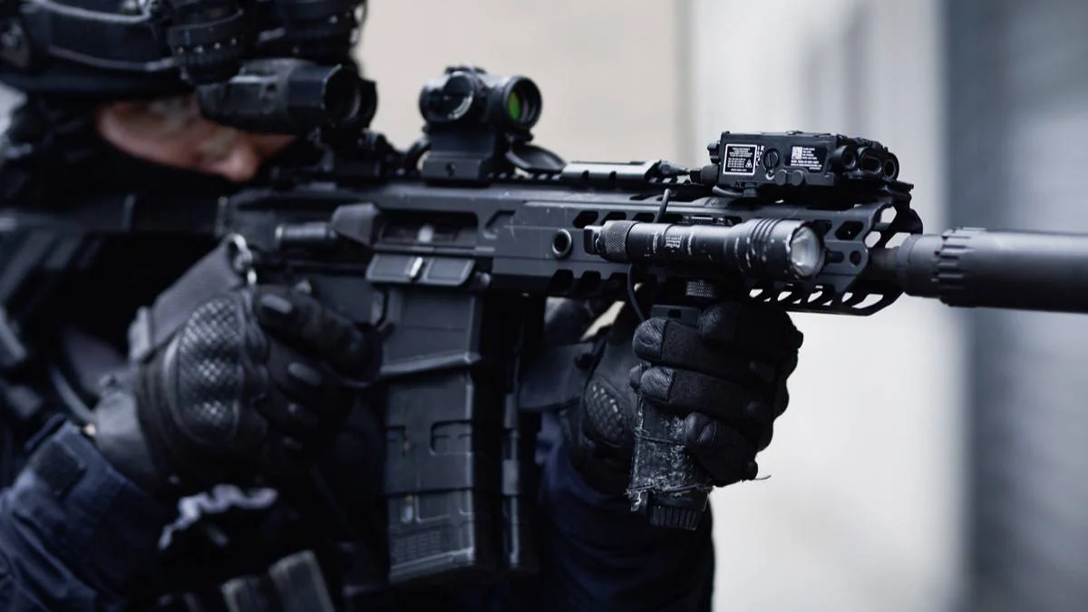The Brolis LP5X laser aiming device mounted on the top rail of a tactical rifle with operator handling