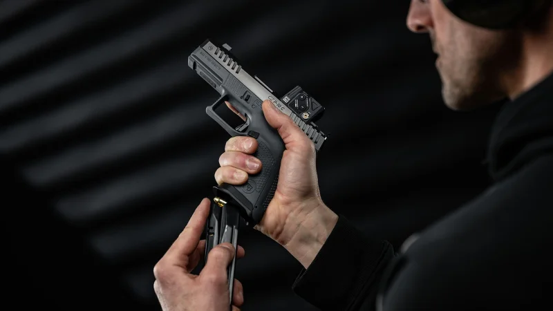 CZ P-10 C Ported COA magazine insertion showing Aimpoint COA, grip ergonomics, and extended magazine