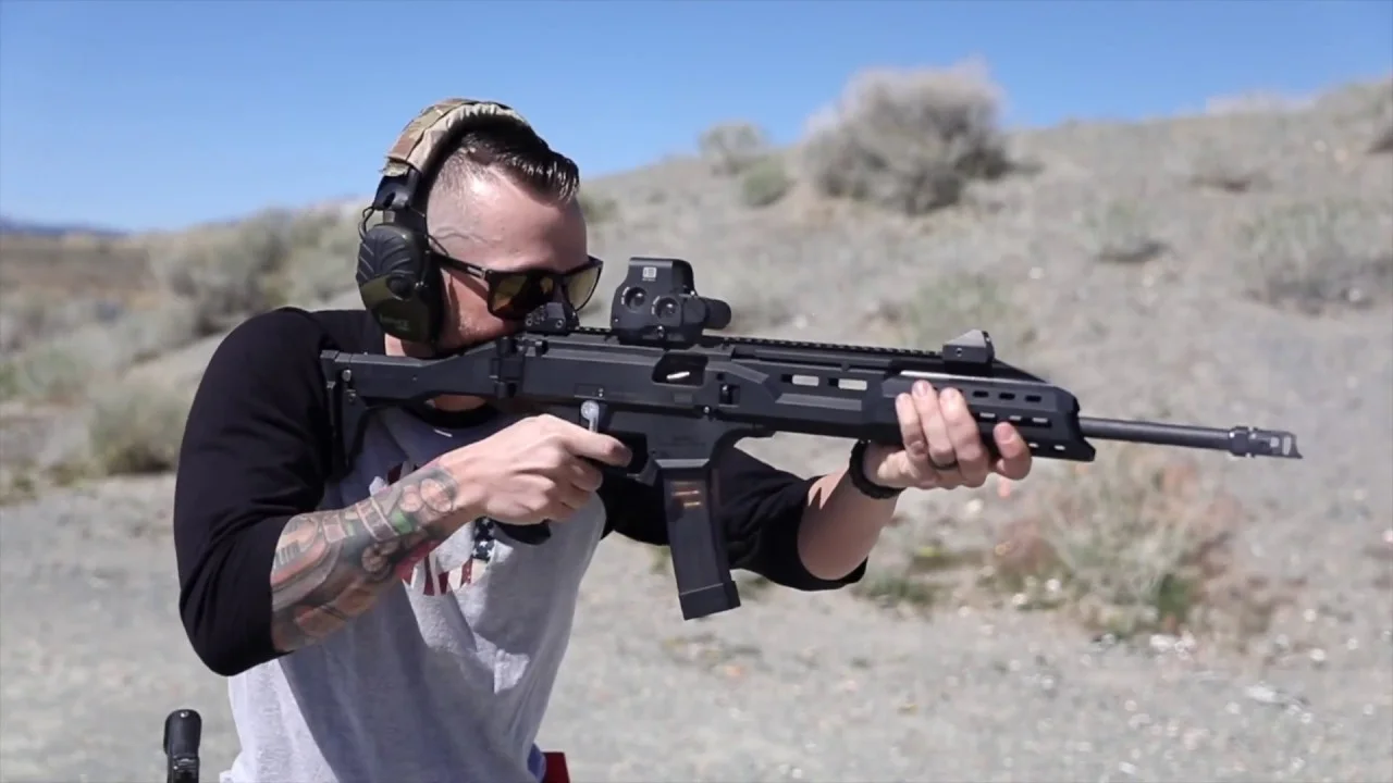 Shooter running a CZ Scorpion carbine with a holographic sight on a desert range