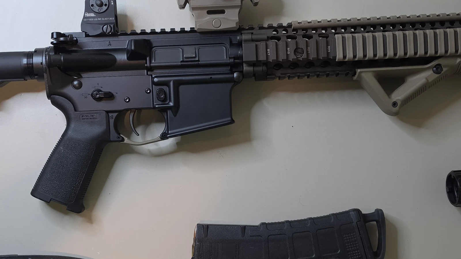 Lower receiver of a Block II carbine showing the trigger, Magpul MOE grip, safety selector, and the Daniel Defense marked fixed rear sight above the charging handle