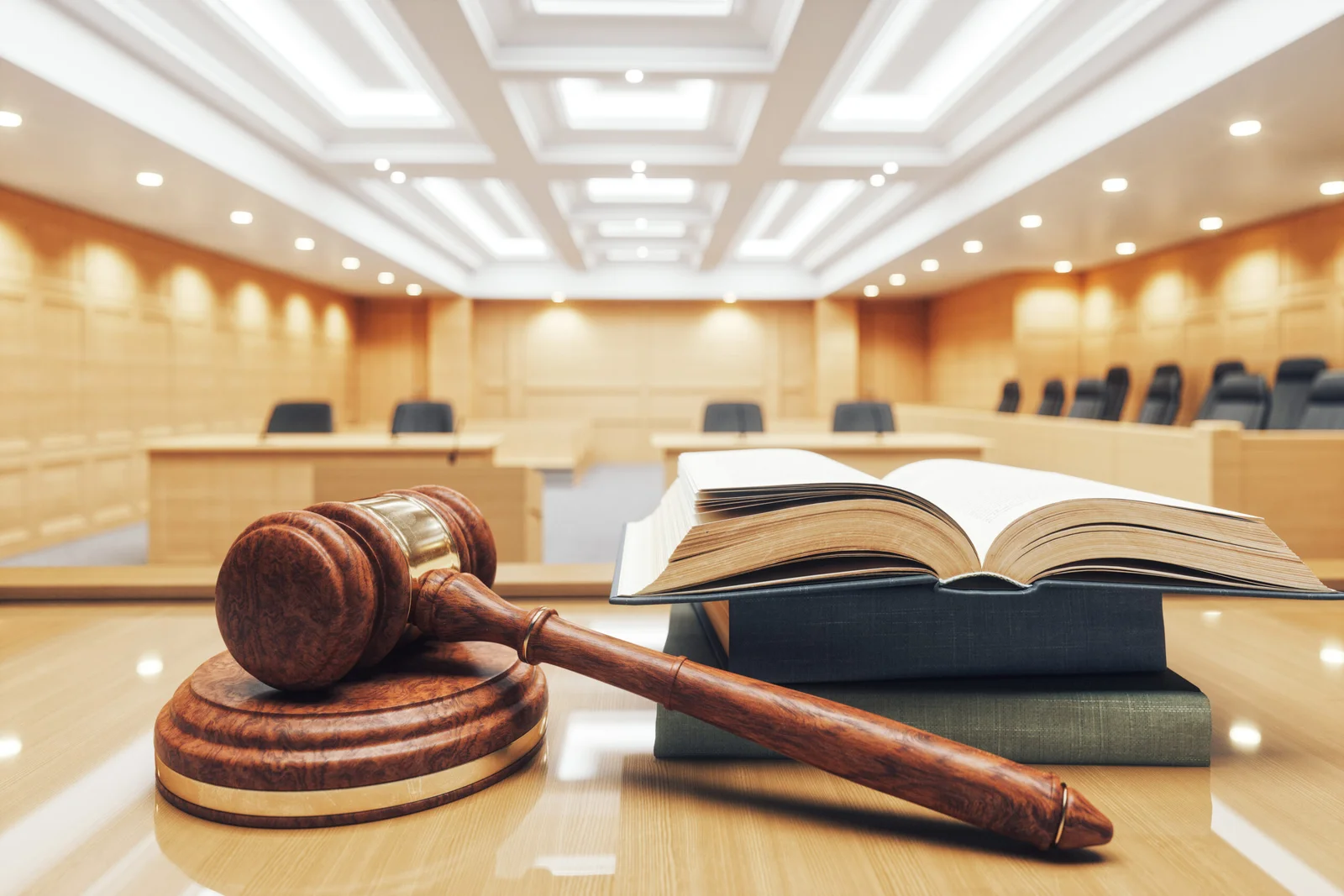 A gavel and law books on a table inside an empty federal courtroom.