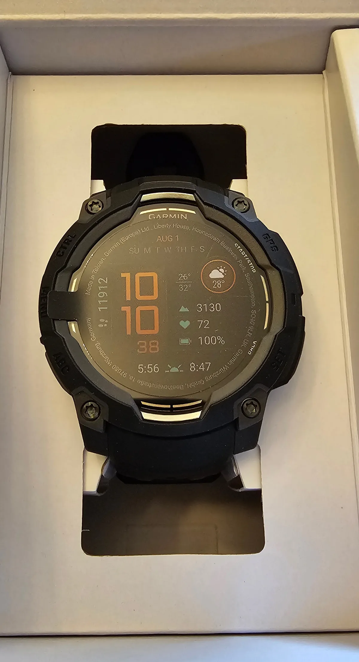 Garmin Instinct 3 AMOLED 45mm in its box, showing the AMOLED watch face, metal-reinforced bezel, and five-button layout