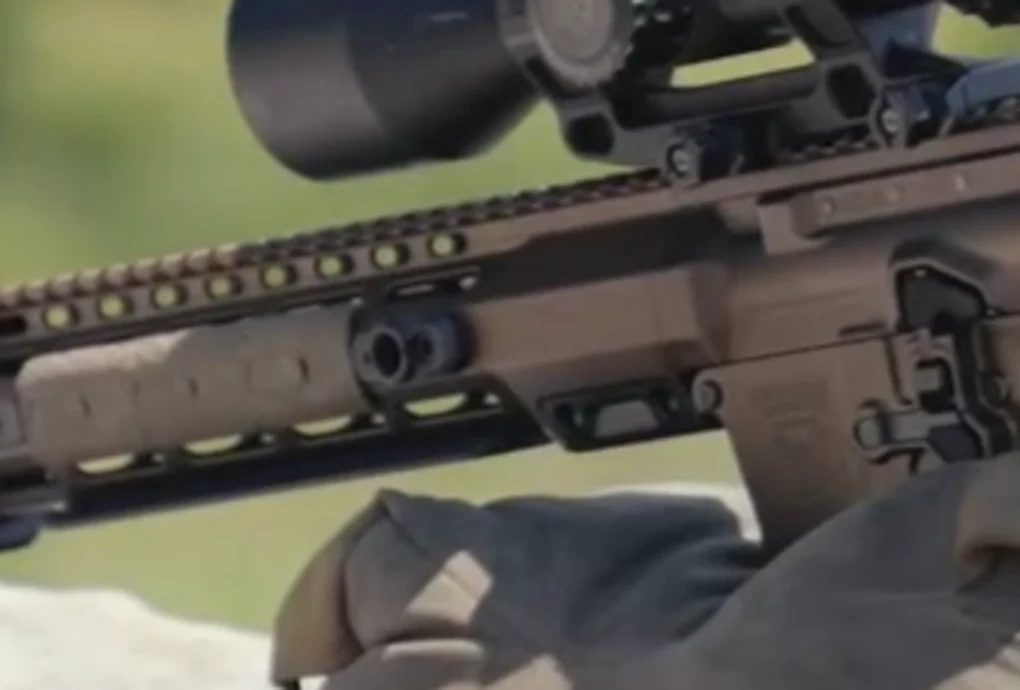 Close-up of the Geissele HICAR prototype's beefed-up handguard root and barrel nut area, showing a deep solid section with an angled gusset and a large circular boss ahead of the upper receiver