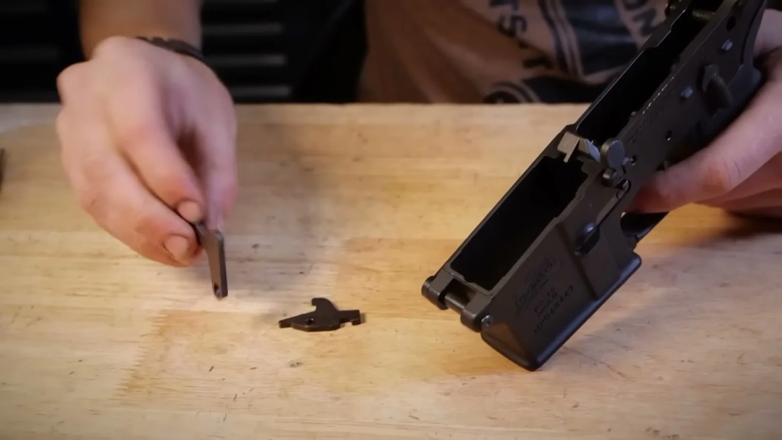 A standard AR-15 disconnector next to the Hoffman Tactical Trigger Kicker, showing the larger L-shaped profile of the Kicker