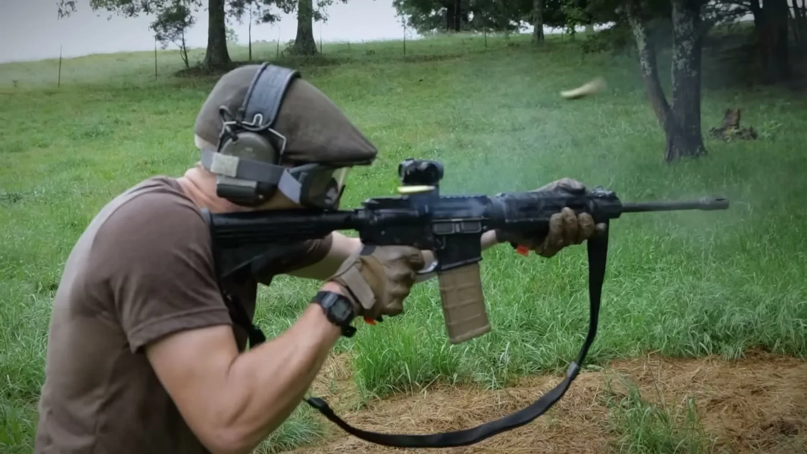 An AR-15 equipped with the Trigger Kicker being fired rapidly on a range, with a spent casing ejecting in mid-air