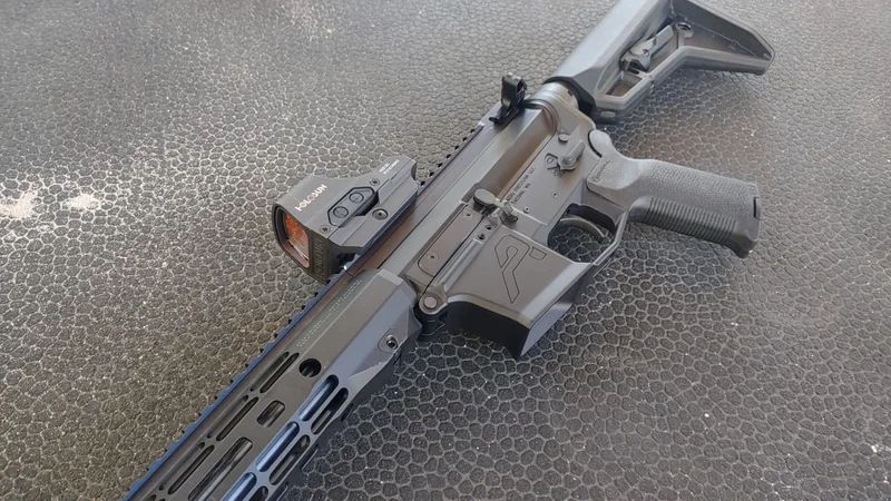 Holosun HE510C-GR Elite open emitter red dot mounted on a rifle, showing the large viewing window and exposed front lens