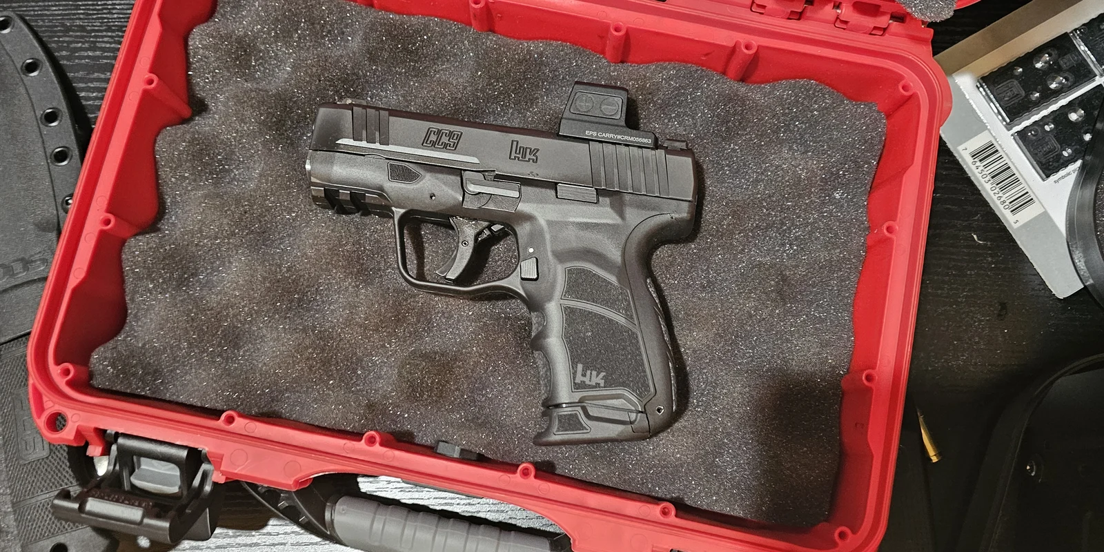 HK CC9 pistol in a red hard case with a Holosun EPS Carry enclosed red dot mounted on the direct-milled Holosun K slide cut, viewed from above