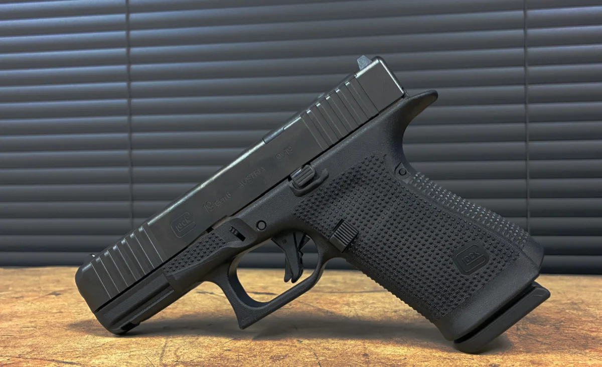 Glock 19 Gen5 striker-fired pistol on a tactical background