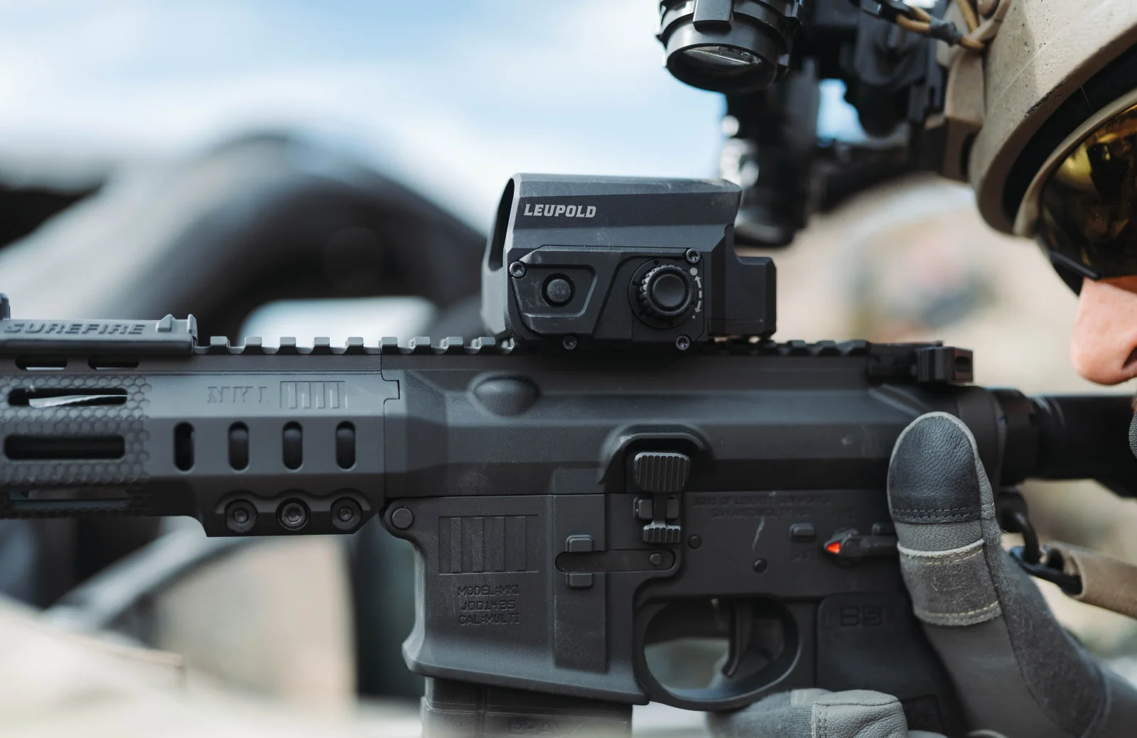 Leupold LCO Pro F2 red dot sight mounted on an AR-15 with a magnifier behind it, held by a shooter