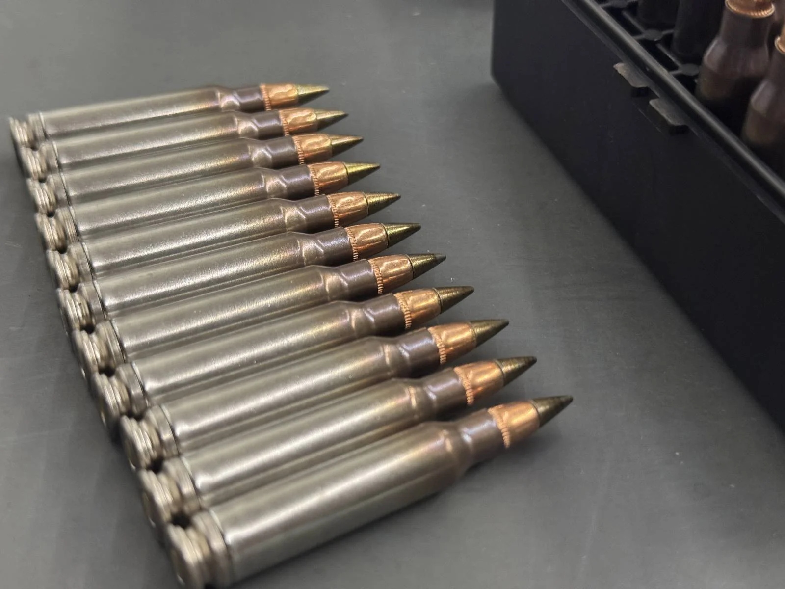 Row of M855A1 Enhanced Performance Round 5.56 cartridges showing the exposed bronze-coated steel penetrator tips over copper slugs