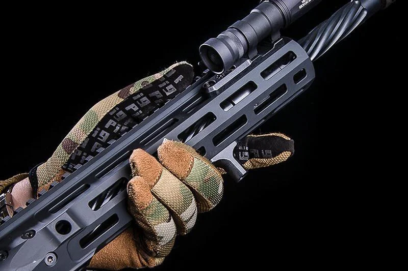 A gloved hand using a finger stop for indexing on an M-LOK handguard