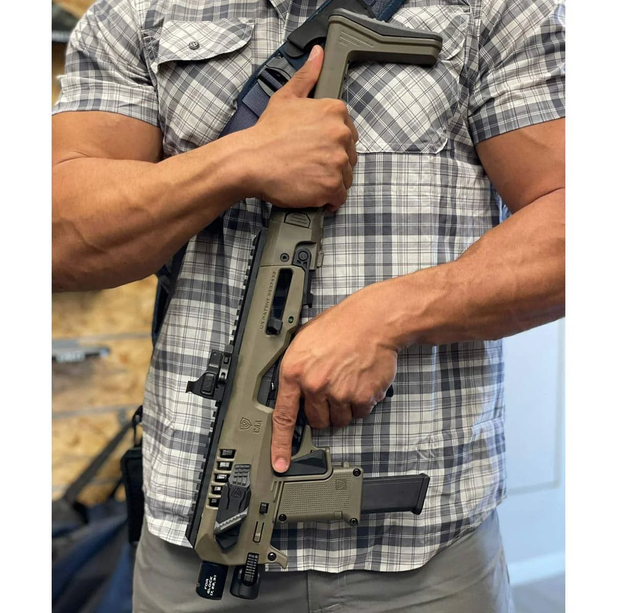 OD Green Roni pistol chassis with red dot optic, spare magazine carrier, and sling