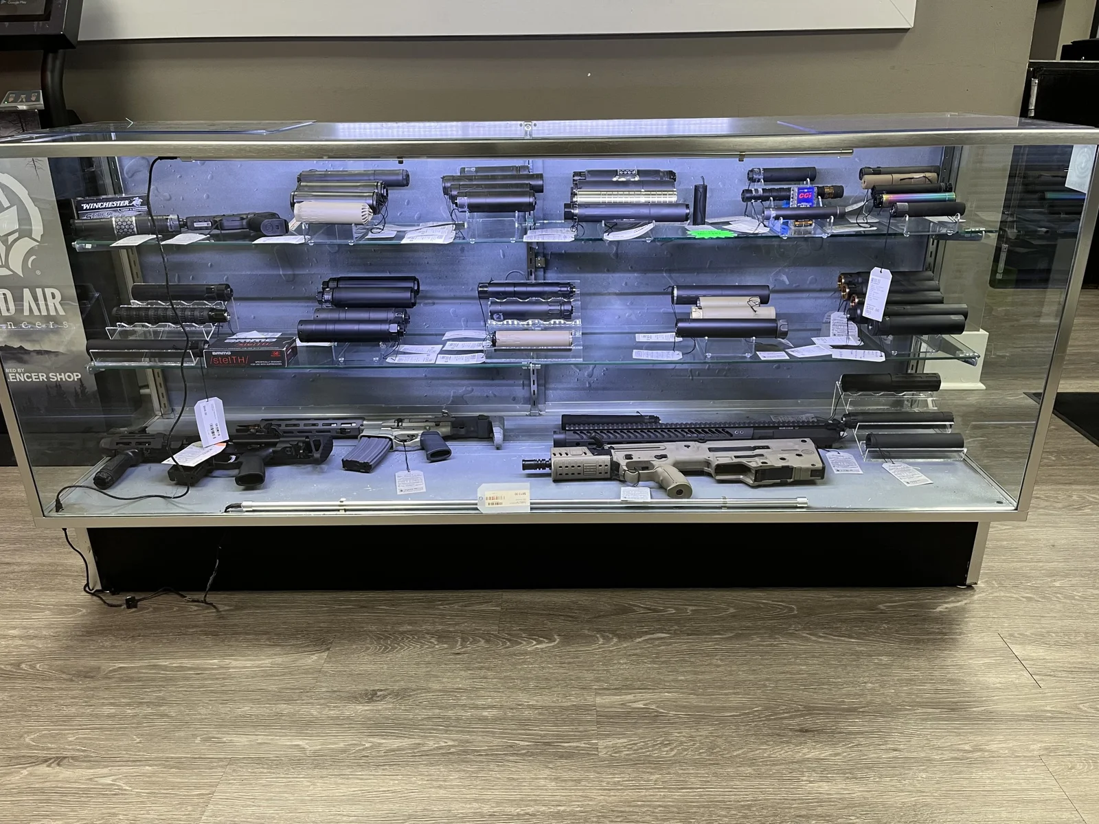 Dealer display case stocked with suppressors and suppressed firearms at a Silencer Shop partner store