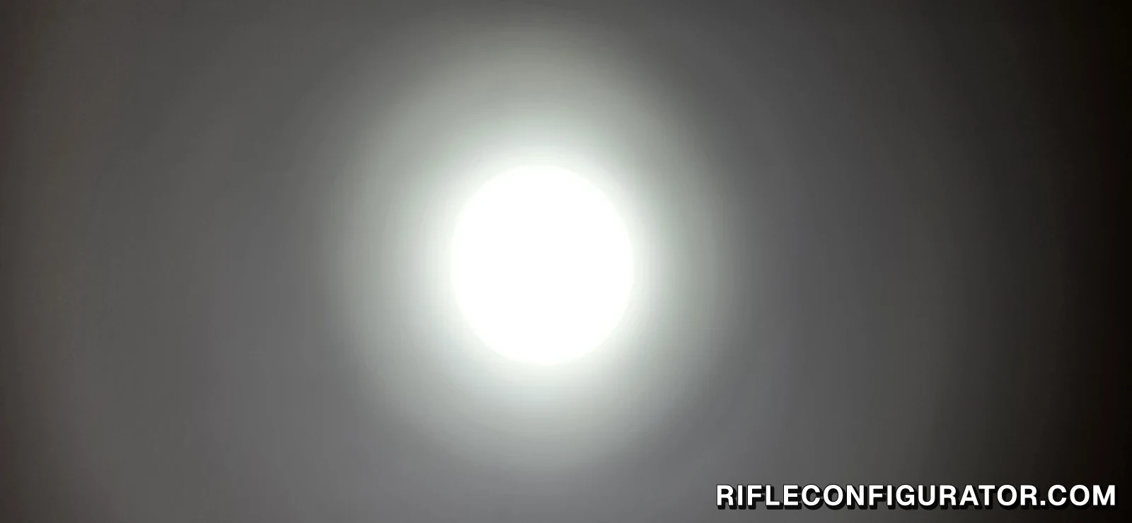 Round hotspot of the OKNIFE MK spotlight projected on a wall in a dark room