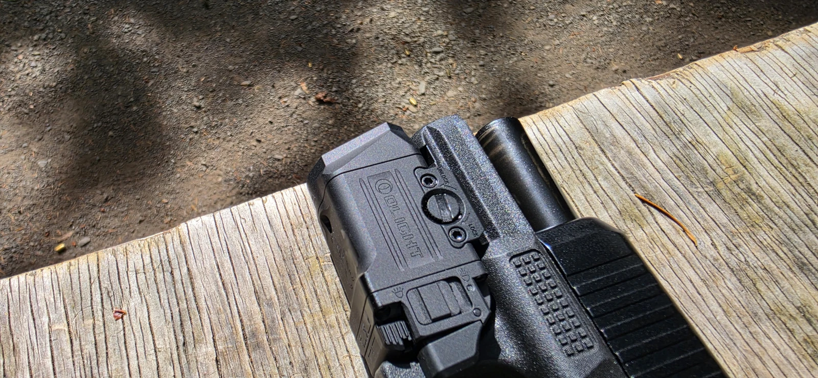 Top of the Olight PL X GL showing the rotary clamp screw marked UNLOCK and LOCK