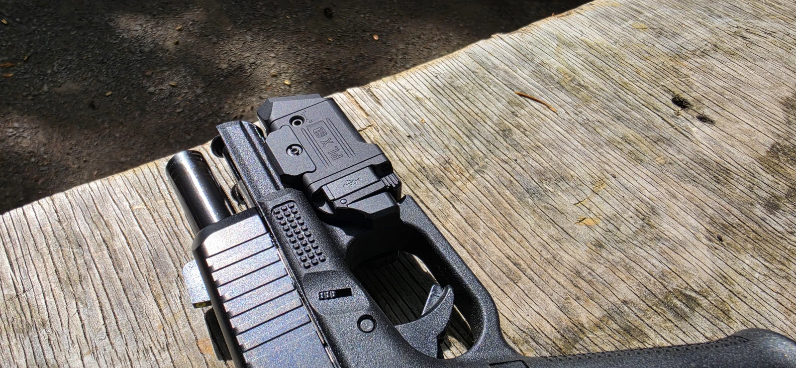 Side of the Olight PL X GL on a Glock showing the USB-C port marked with a USB icon