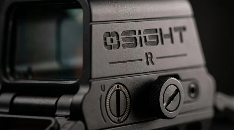 Close-up of the Osight-R control cluster showing the brightness dial, battery cap, and housing branding