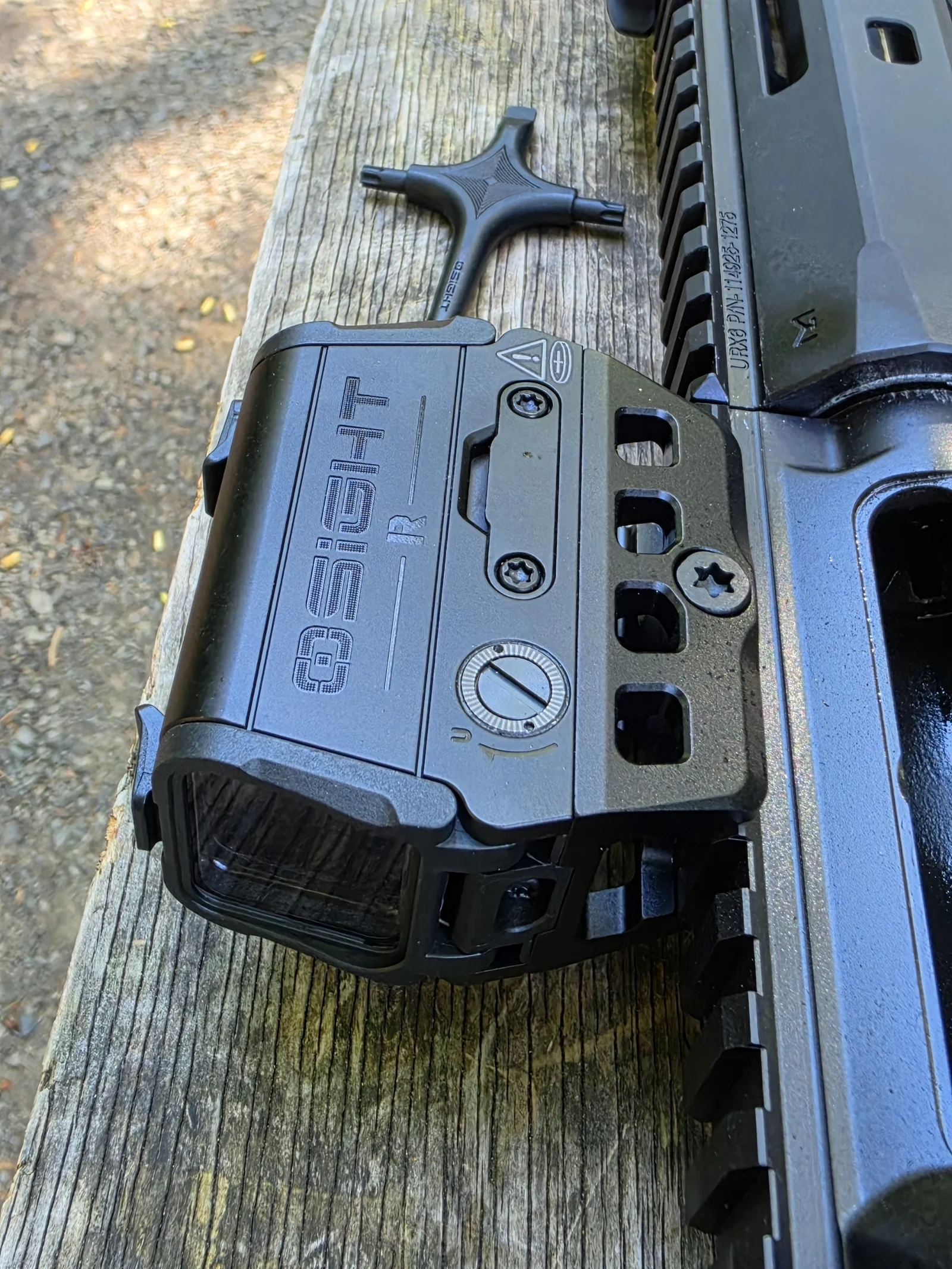 Osight R on its included mount beside the included T-handle adjustment tool on a range bench