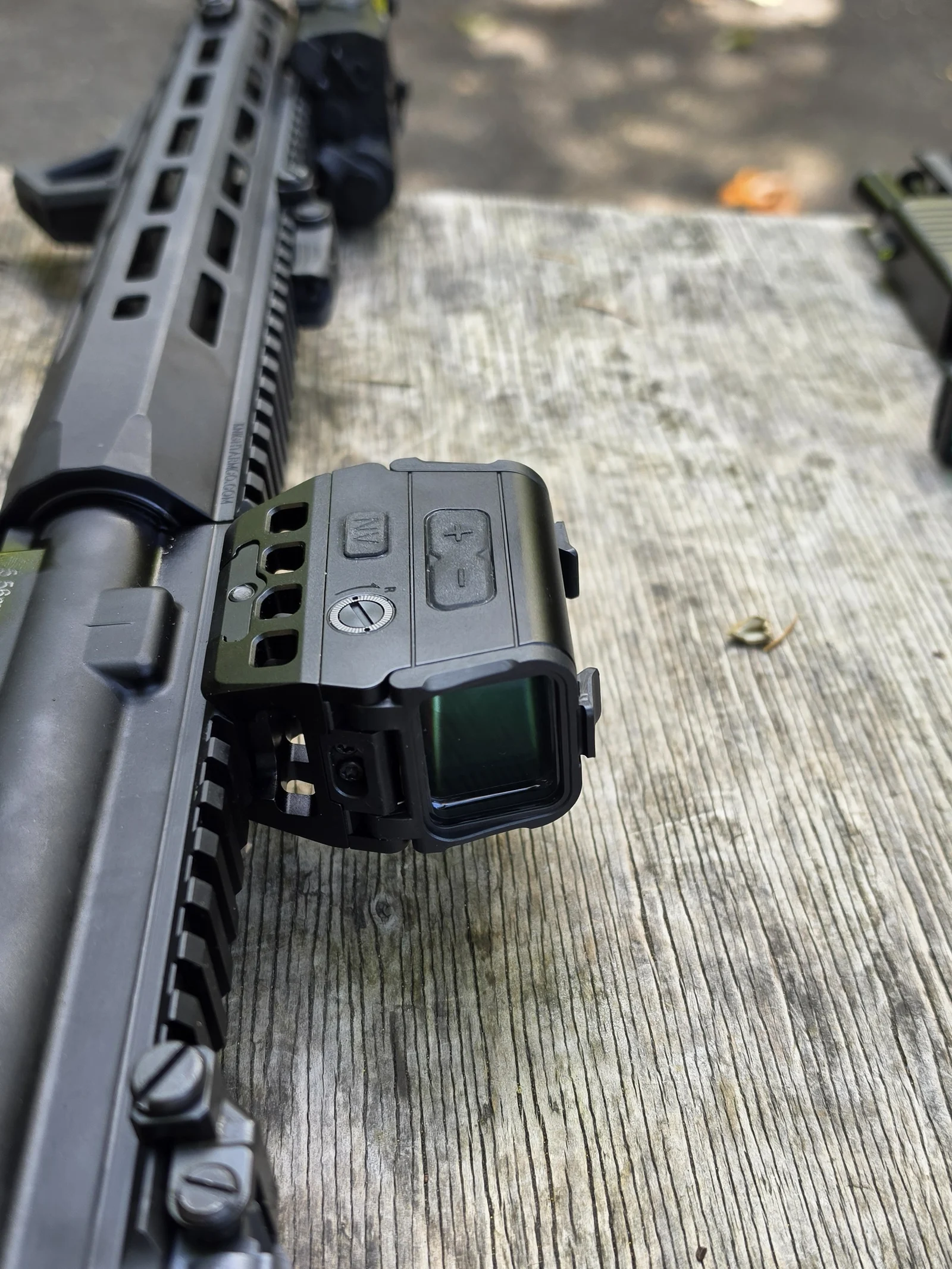 Osight R mounted on the suppressed SR-15, control side up, showing the brightness rocker, NV button, and windage screw