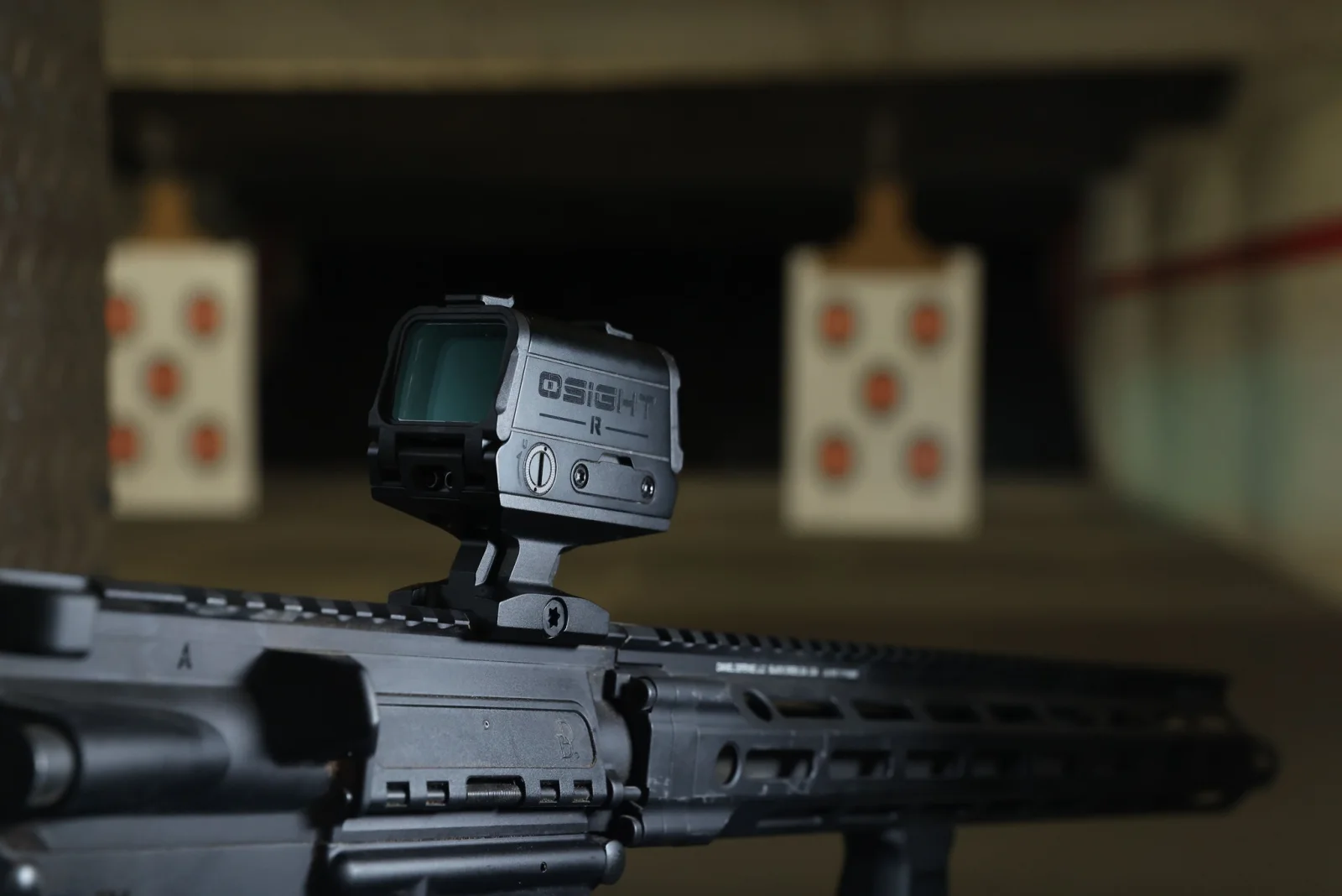Osight-R mounted on a rifle at an indoor range on a taller riser-style base