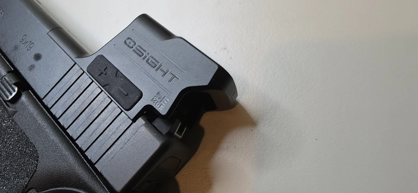 Left side of the Osight SE MOS mounted on a Glock 47 slide, showing the plus and minus brightness buttons and the OSIGHT SE MOS markings