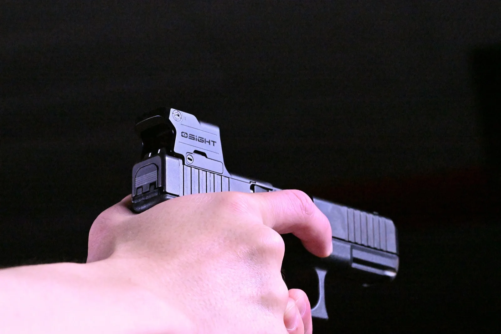 Osight SE MOS on a Glock presented toward the camera, showing the enclosed optic housing and the side brightness buttons