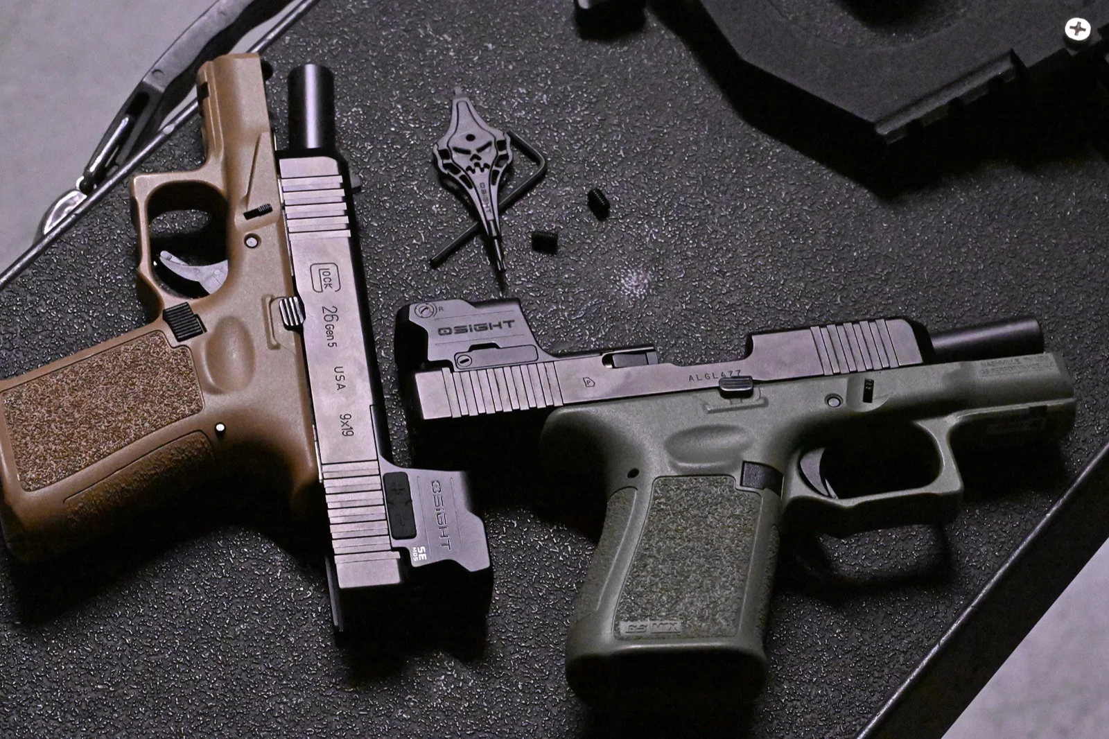 Osight SE MOS mounted directly on an OD green Glock-pattern slide next to the supplied skull-profile driver and spare mounting screws