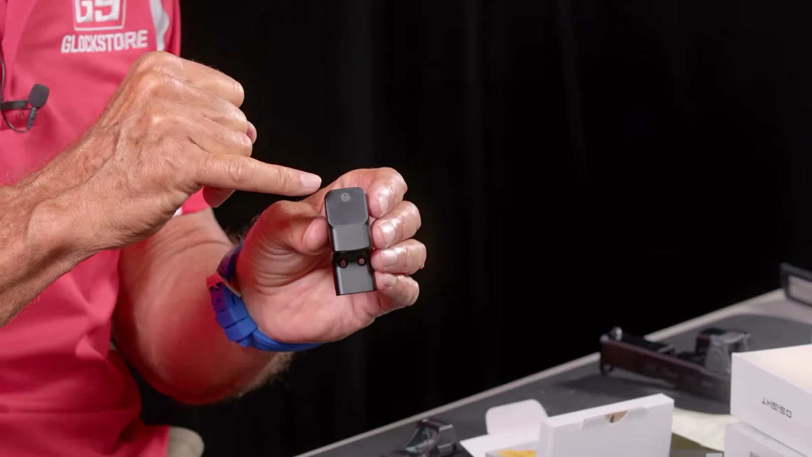 Osight SE MOS held in hand showing the enclosed housing profile and the integrated MOS mounting base with screw holes