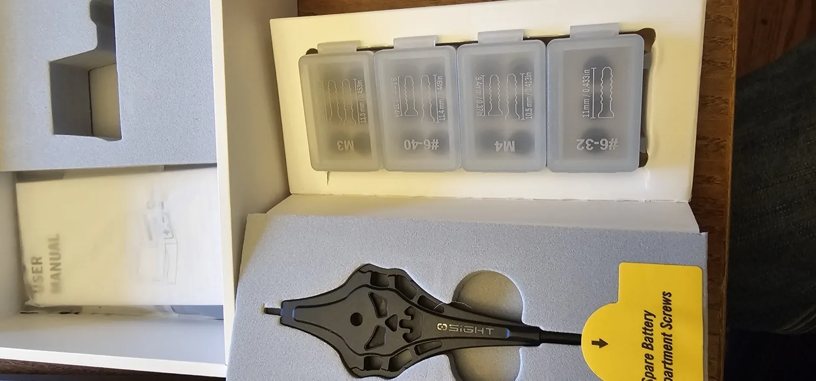 Included mounting hardware: four screw types in labeled trays plus a branded torque key